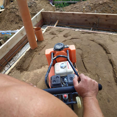 Working with a vibrating machine and equipment, soil compaction with a vibrating plate.new
