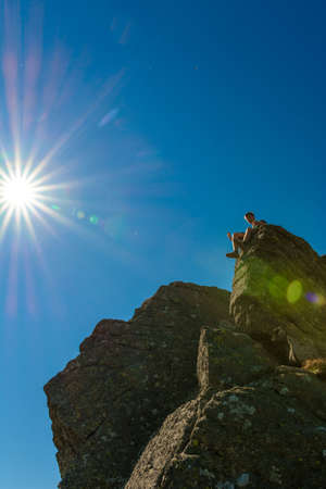 A tourist on top of a large stone block, the top of Smotrych mountain, one of the rocky peaks of the Ukrainian Carpathians. 2020の写真素材