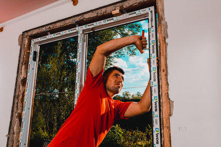 Dolyna, Ukraine July 31, 2020: an employee installs a window frame, installing a plastic window. newのeditorial素材