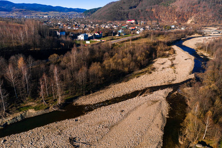 Carpathian village in Ukraine, autumn view of the village, river and mountains from a birds eye view, aerial photography of the Carpathian region.の写真素材
