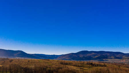Carpathian village in Ukraine, autumn view of the village, river and mountains from a birds eye...