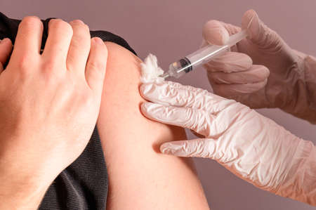 Vaccination close up, injection of vaccine in hand, doctor in white gloves. newの写真素材