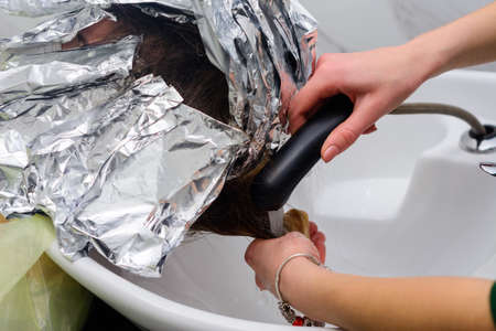 Washing hair dye from a hairdresser, removing foil from hair. new