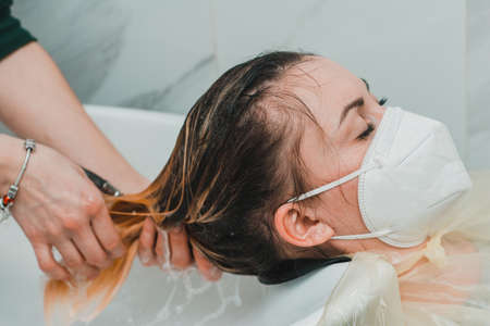 Woman in a barbershop dyes her hair, washing her head in the process of dyeing her hair. new