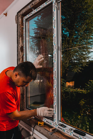 Dolyna, Ukraine July 31, 2020: an employee installs a window in the house, installation of a plastic window, wds windows, energy-saving windows.newのeditorial素材
