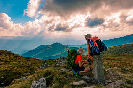 Carpathians, Ukraine August 23, 2020: A young couple of tourists on vacation at the top of the mountain, enjoying the views of the Montenegrin ridge and pretty valleys. newのeditorial素材