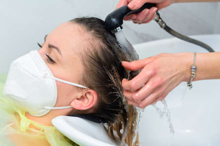 The hairdresser washes off the hair dye, scalp wash and hair dyeing process. newの写真素材
