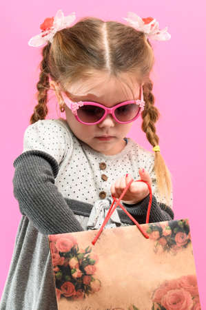 Little girl shopping, baby portrait on pink background, baby shopping. newの写真素材