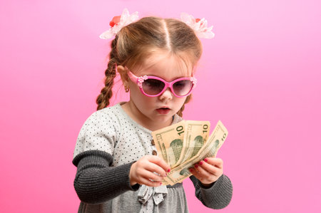 Girl holding paper US dollars, rich and happy child, child and money. newの写真素材