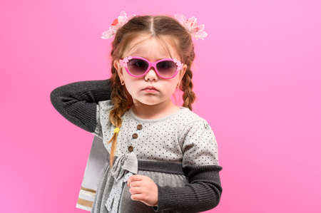Little girl shopping, baby portrait on pink background, baby shopping.