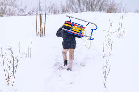 The guy is sledding down the hill, winter joys when it's snowing in the yard. new