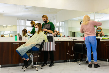 Dolyna, Ivano-Frankivsk March 5, 2021: The work of a stylist, stylist dyes the client's hair, lighting in white, work during a pandemic.のeditorial素材