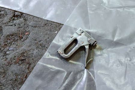Stapler for repair and construction work, working tool close up, stapler lying on the floor.