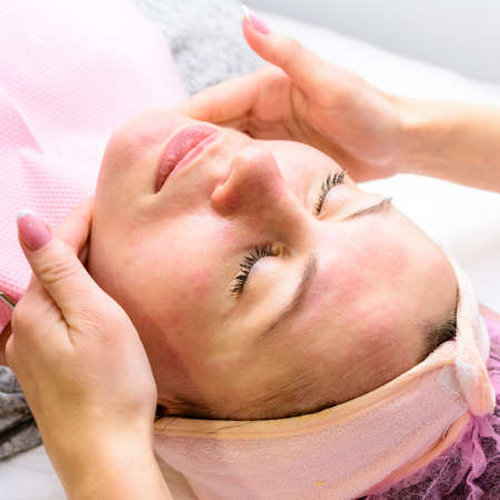 Happy and relaxed woman on cosmetology procedures, massage and applying face cream. newの写真素材