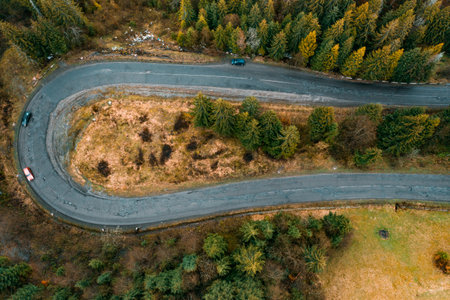 steep and dangerous turns on the road, serpentine roads in the woods, top view of the serpentine and...