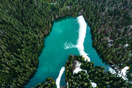Lake Synevyr in the Carpathians, top view of the lake, mountain lake covered with ice, ice line on Lake Synevyr, National Park.の写真素材