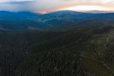 Cloudy skies over the mountains, rainy spring clouds over the forest and mountain tops, fog between the mountains.の写真素材