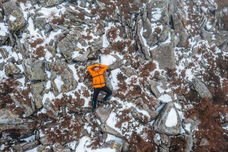 The tourist lies on a rock near Mount Petros, bright clothes for tourists.の写真素材