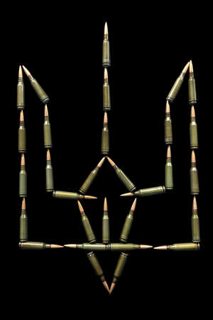 National emblem of Ukraine from automatic cartridges isolated in black background close up.