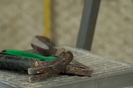 A set of three construction tools on a ladder hammer, pliers and screwdriver, construction and...