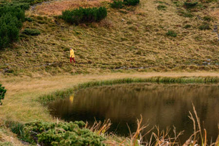 Light waves on Lake Nesamovite, a reflection of a woman in the water, a girl walking near Lake Nesamovite in bright clothes, the color of the water is black.の写真素材