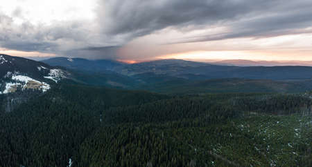 Cloudy skies over the mountains, rainy spring clouds over the forest and mountain tops, fog between the mountains.の写真素材