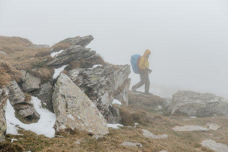 Carpathians, Ukraine September 25, 2021: tourists climb Mount Petros, Mount Petros in fog and snow, tourists in bright clothes, the beginning of winter on Mount Petros.のeditorial素材