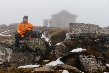 Carpathians, Ukraine September 25, 2021: tourists climb Mount Petros, Mount Petros in fog and snow, tourists in bright clothes, the beginning of winter on Mount Petros.のeditorial素材