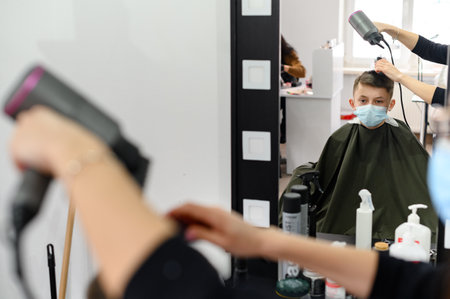 Dolyna, Ukraine February 3, 2022: visit to the hairdresser, children's haircut, hairdressers in Ukraine during quarantine, stylish hairdresser.のeditorial素材