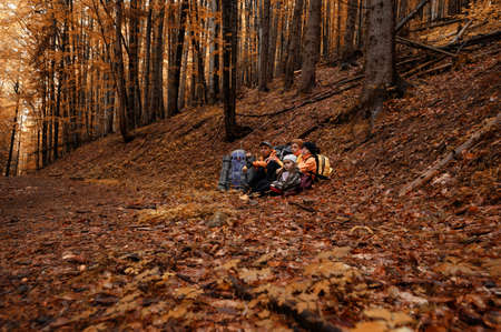 Portrait of a family sitting down to rest during a hike in the mountains, family vacation in the Carpathians.の写真素材