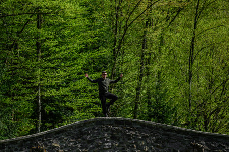 A man stands with one foot on the wall of the Gothic style, a photo shoot in abandoned and forgotten places, forgotten historical places.の写真素材