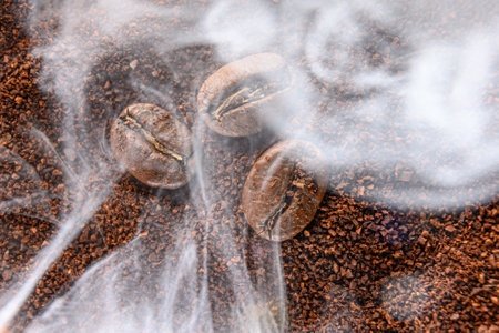 top view of coffee beans and ground coffee steaming with heat, roasted coffee, smoky coffee texture.の写真素材