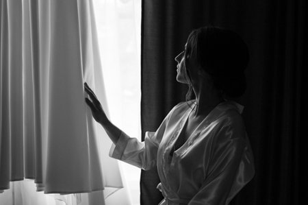 Ivano-Frankivsk, Ukraine June 26, 2021: the bride examines her dress by the window, the morning ritual of the bride.のeditorial素材