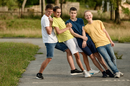 Ivano-Frankivsk, Ukraine July 14, 2022: photo of teenagers on a sports field, three boys leaning on one who is holding them.のeditorial素材