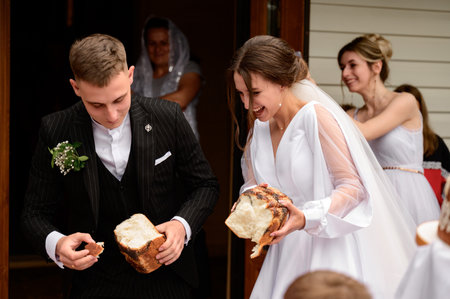 Ivano-Frankivsk, Ukraine June 26, 2021:Ukrainian wedding tradition is to dip bread in honey and eat it, sweet bun with honey at a wedding.のeditorial素材