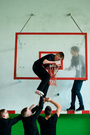 Ivano-Frankivsk, Ukraine May 15, 2021: students drop a classmate on the basketball hoop, school gym,...
