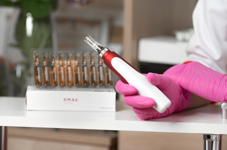 The cosmetologist holds in his hands a dermapen, a tool for mesotherapy and cell regeneration, a cosmetologist's office.のeditorial素材