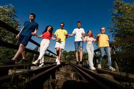 Ivano-Frankivsk, Ukraine July 14, 2022: A group of teenagers take pictures on a railway bridge over...