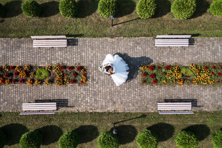 Ivano-Frankivsk, Ukraine 2021: The newlyweds walk through the churchyard, top view of a couple of people.のeditorial素材