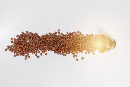 Path of coffee beans spilled from a mug, coffee on an isolated white background, copy space for text.の写真素材