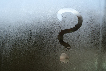 Fogged glass, a question mark is written on the window with condensation, texture on the glass with...