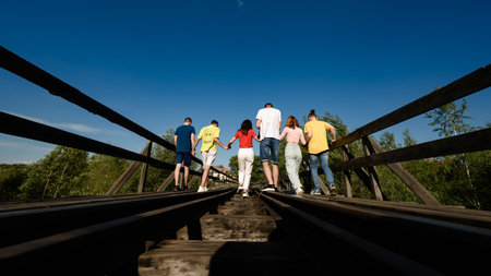 Ivano-Frankivsk, Ukraine July 14, 2022: A group of teenagers take pictures on a railway bridge over...