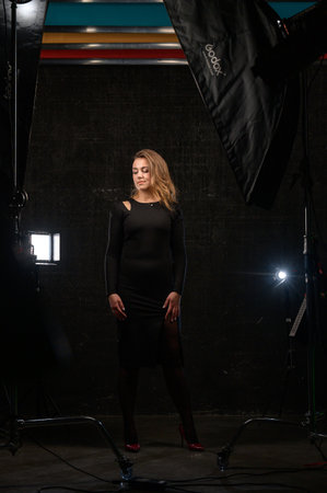 Ivano-Frankivsk, Ukraine January 30, 2022: full-length portrait of a girl in a studio, a model in a black dress on a black background.のeditorial素材