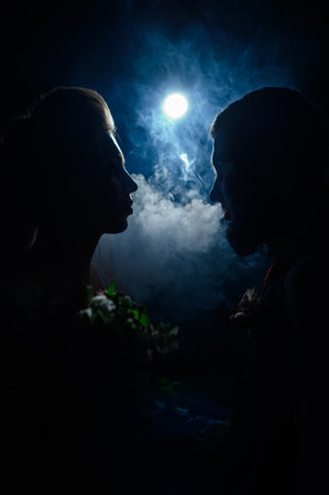 Ivano-Frankivsk, Ukraine July 31, 2022: A loving couple looks into each other's eyes, silhouettes of people in smoke on a black illuminated background, a romantic evening for the lovers.のeditorial素材