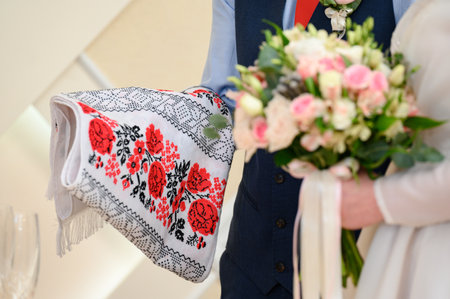 The bridegroom holds an embroidered towel and the bride of flowers, wedding ceremony, Ukrainian wedding.の写真素材