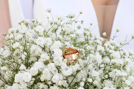 Bride's bouquet with white flowers close-up, wedding rings on the bouquet.の写真素材