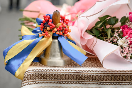 school traditional metal bell in yellow and blue ribbons, Ukrainian first bell with viburnum bunch and flag colors.の写真素材