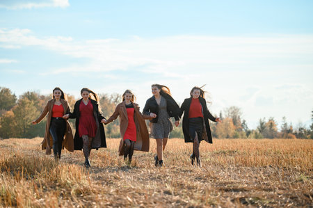 Ivano-Frankivsk, Ukraine October 14, 2022: girls classmates hold hands and go to the rhythm, autumn walk of friends.のeditorial素材