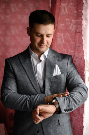 Ivano-Frankivsk, Ukraine July 31, 2022: A man looks at the clock, a watch on a man's hand, a man's classic style of clothing.のeditorial素材