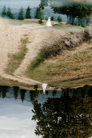 Ivano-Frankivsk, Ukraine September 30, 2021: newlyweds walk in the autumn park, Ukrainian bride couple with reflection in the mirror.のeditorial素材
